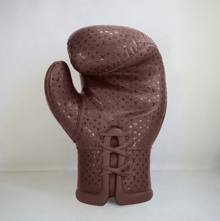 Brown boxing glove with an embossed pattern featuring logos and symbols.