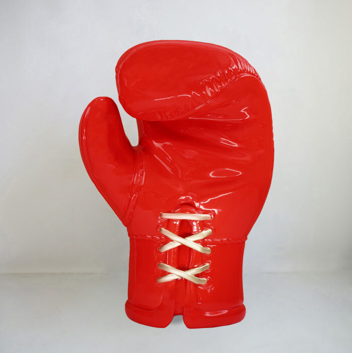 Giant red boxing glove sculpture with white laces.