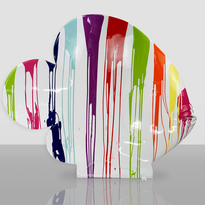 Colorful sculpture of a fish with a rounded shape, decorated with vertical paint drips in various vibrant colors.