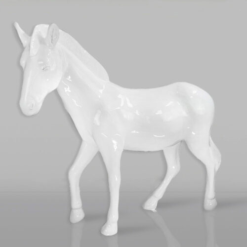 White ceramic unicorn statue on a gray background.