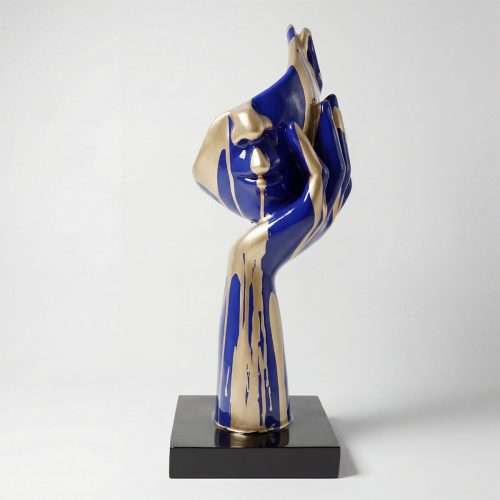 figure hand and face sculpture in glossy blue and gold laminate on black base, artistic decorative piece for interiors or events