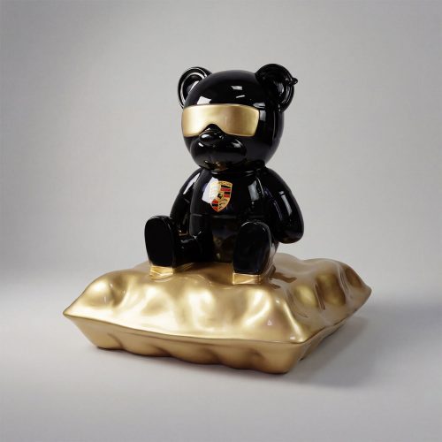figure bear sculpture in glossy black fiberglass with gold visor and crest, sitting on metallic gold cushion for decor or advertising