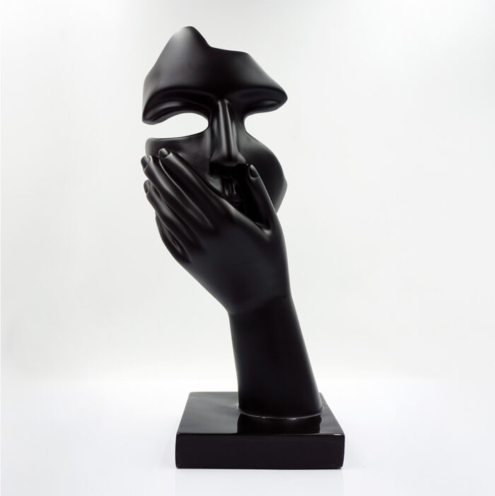 Black abstract sculpture of a hand covering a face mask.