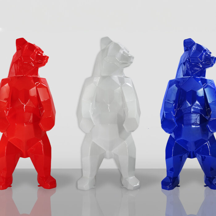 Three geometric bear sculptures in red, white, and blue against a plain background.