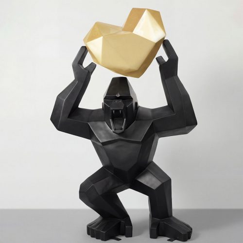 sculpture gorilla figure in faceted black fiberglass holding a geometric gold laminate rock, decorative display or mall prop