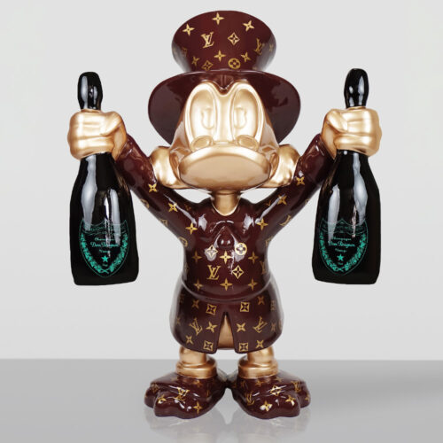 Stylized figurine of a character resembling Donald Duck wearing a brown top hat and coat decorated with a gold Louis Vuitton monogram pattern, holding a bottle of Dom Pérignon champagne in each hand against a plain light background.
