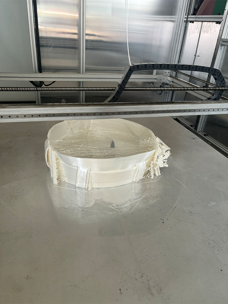 Duża biała figura z laminatu w trakcie produkcji na stole CNC, rzeźba artystyczna o zaokrąglonym kształcie.