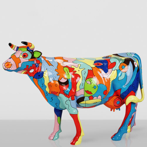 Colorful cow sculpture painted with abstract shapes and faces in bright colors including blue, red, yellow, green, and orange, standing on a plain light gray background.
