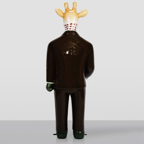 Ceramic figurine of a giraffe wearing a dark brown suit, viewed from the back against a neutral gray background.