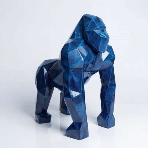 figure gorilla sculpture in glossy faceted blue laminate or fiberglass, geometric artistic style for decor or advertising