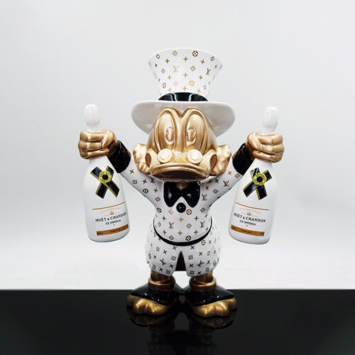 A decorative figurine of a duck character dressed in a white and gold Louis Vuitton patterned outfit and top hat, holding two white Moët & Chandon Ice Imperial champagne bottles, standing on a reflective black surface against a plain white background.
