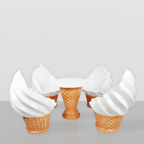 A whimsical furniture set consisting of a table and four chairs designed to look like ice cream cones with white swirl ice cream tops, on a reflective surface against a plain light gray background.
