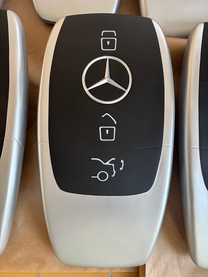 Duża figura reklamowa w kształcie pilota Mercedes wykonana jako figura z laminatu z włókna szklanego, srebrno-czarna, z logo.