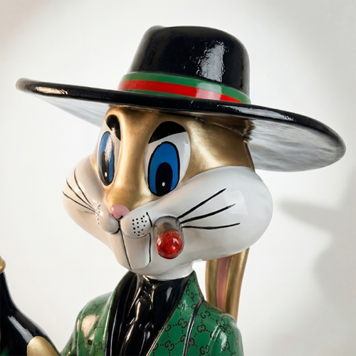 figure rabbit sculpture in glossy fiberglass, stylized cartoon rabbit with black wide-brim hat and green patterned suit for display or advertising