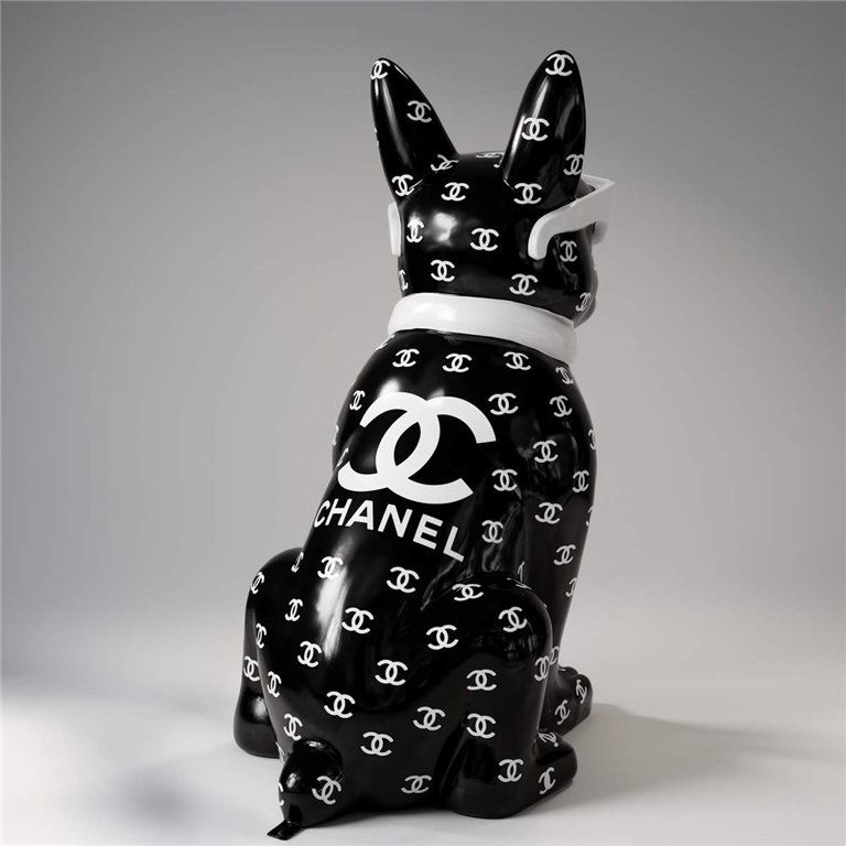 A black ceramic dog figurine wearing white sunglasses and a white scarf, covered in a pattern of interlocking white 